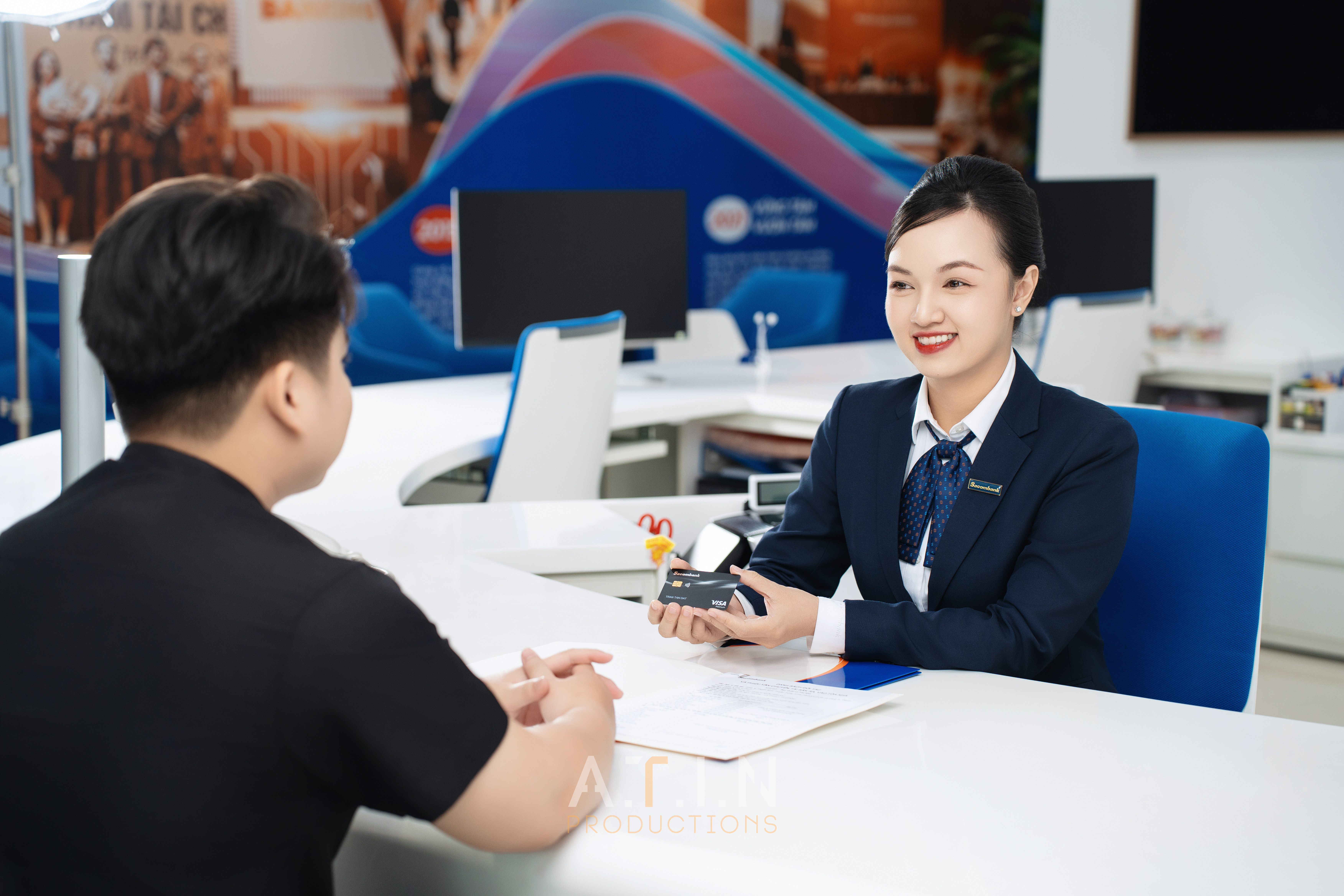 Toàn cảnh một hội thảo doanh nghiệp với banner thương hiệu, nhiếp ảnh gia ATIN đang chụp diễn giả trên sân khấu